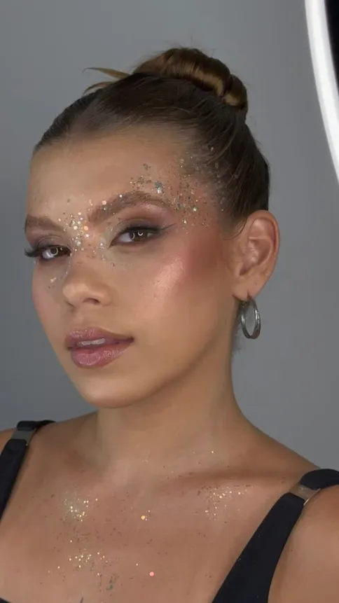 Maquiagem editorial com glitter no rosto e no colo